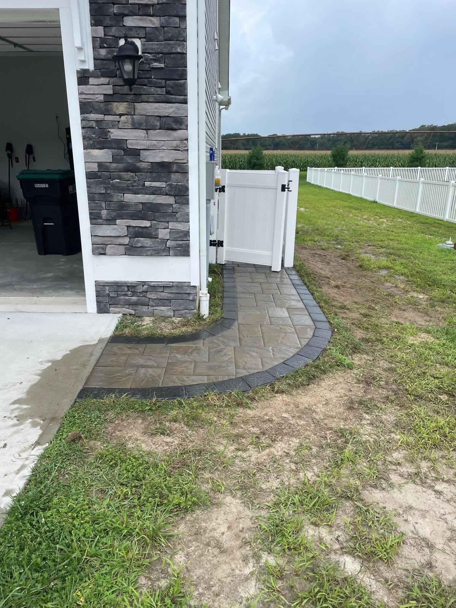 Curved paver walkway along the side of a home